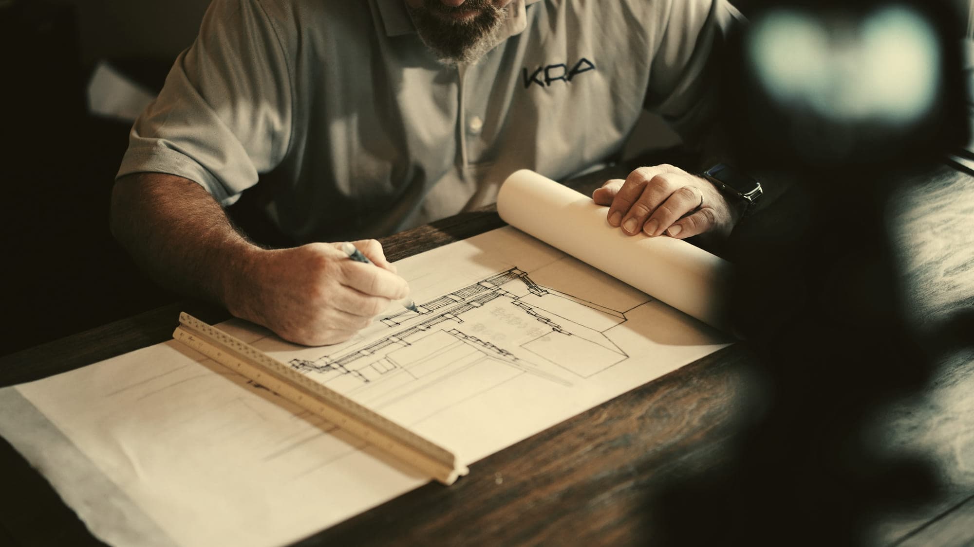 Technical drawings, notes, and rules laid out on a workshop desk